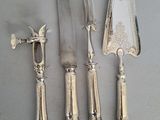 four pieces of silverware including a knife, fork, and spoon