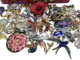 a red box filled with lots of different types of brooches