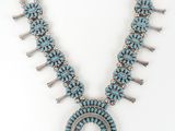 a necklace with turquoise stones and silver beads on a white background