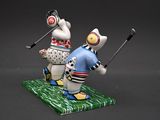 two figurines of a man and a woman playing golf