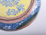 a yellow vase with a blue and red design on it