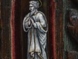 a statue of a man holding a cross in a wooden frame