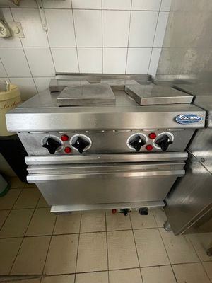 une cuisinière argentée à trois feux dans une cuisine