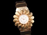 a gold watch with a white face on a black background