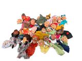a lot of dolls that are sitting on a white surface