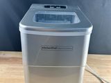 a close up of a small ice maker on a wooden table
