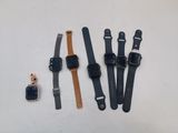 Quatre modèles de montres différents sont disposés sur une surface blanche