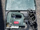 une boîte verte contenant un cordon d'alimentation et un outil