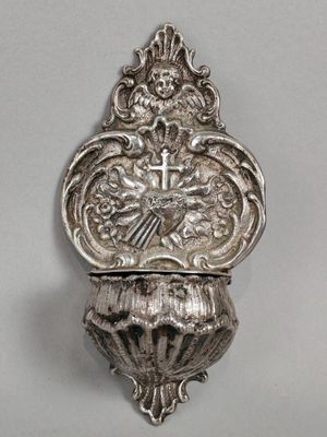 un plat en argent finement décoré, orné d'une croix et d'un oiseau