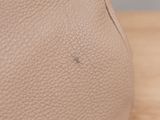 a close up of a handbag on a table with a wooden surface