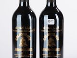 deux bouteilles de vin posées l'une à côté de l'autre sur une surface blanche