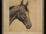 painting of a horse in a gold frame on a table