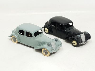 two toy cars sitting next to each other on a white surface