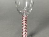 a wine glass with a red and white striped stem