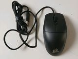 a black computer mouse and a black cord on a white surface