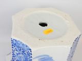 a blue and white vase with a flower design on it