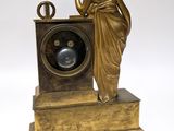 a statue of a woman standing next to a clock