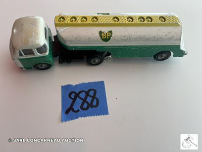 un camion vert et blanc et un autocollant bleu posé sur une table