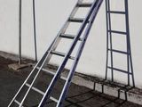 a ladder leaning against a wall on the side of the road