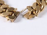 an image of a close up of a gold bracelet on a white surface