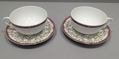 two cups and saucers are sitting on a table