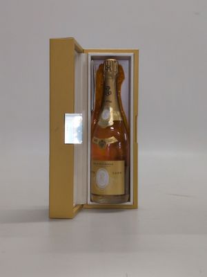 une bouteille de champagne dans un coffret, posée sur une surface blanche