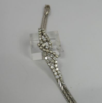 a close up of a silver bracelet on a white surface