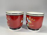 pair of red and white cups with floral designs on them