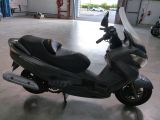 a scooter parked in a garage with a surfboard on the back of it