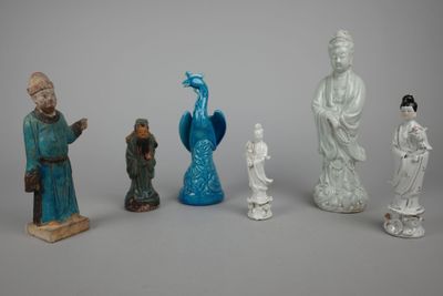 five figurines of asian people and a peacock