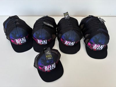 six black hats with pink and blue designs on them sitting on a table