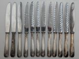 five knives and six knives on a white table