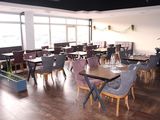 tables and chairs in a restaurant with a piano in the background