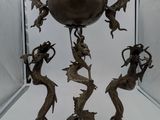 a bronze sculpture of a group of mermaids on a pedestal