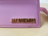 a close up of a pink purse with the word jaquemus on it