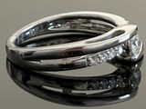 a close up of a diamond ring on a reflective surface
