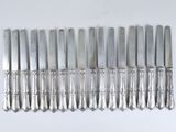 eight silverware knives on a white table
