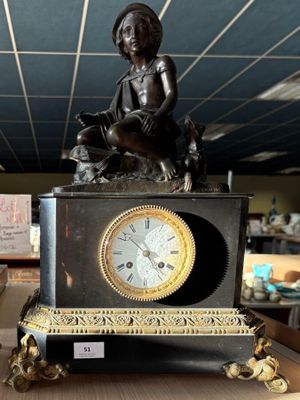 une statue représentant une femme assise sur une horloge posée sur une table