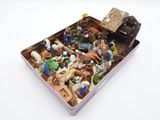 toy figurines in a tin container on a white surface
