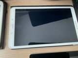 une tablette posée sur un bureau, à côté d'un clavier
