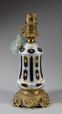a white and gold vase with a bird on top