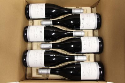 six bottles of wine in a cardboard box on a table