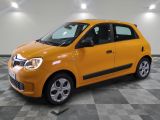 La petite voiture jaune est garée dans le garage, sur le sol à damier.