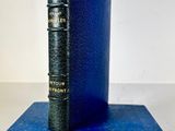 an old blue book sitting on top of a blue book stand