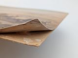a person holding a piece of paper on top of a piece of cardboard