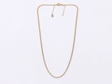 a gold necklace and earring set on a white background