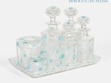 un plateau en verre sur lequel sont posés de nombreuses bouteilles et verres