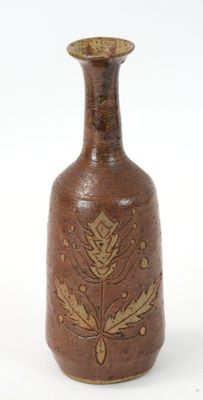 a brown vase with a gold leaf design on it