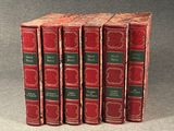 four red books are lined up in a row on a gray surface