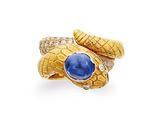 a close up of a gold snake ring with a blue stone